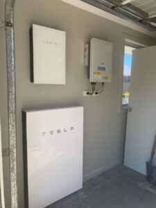 Tesla Powerwall installed at Tanilba Bay NSW, connected to a solar power system featuring a FIMER inverter and Solahart Silhouette solar panels