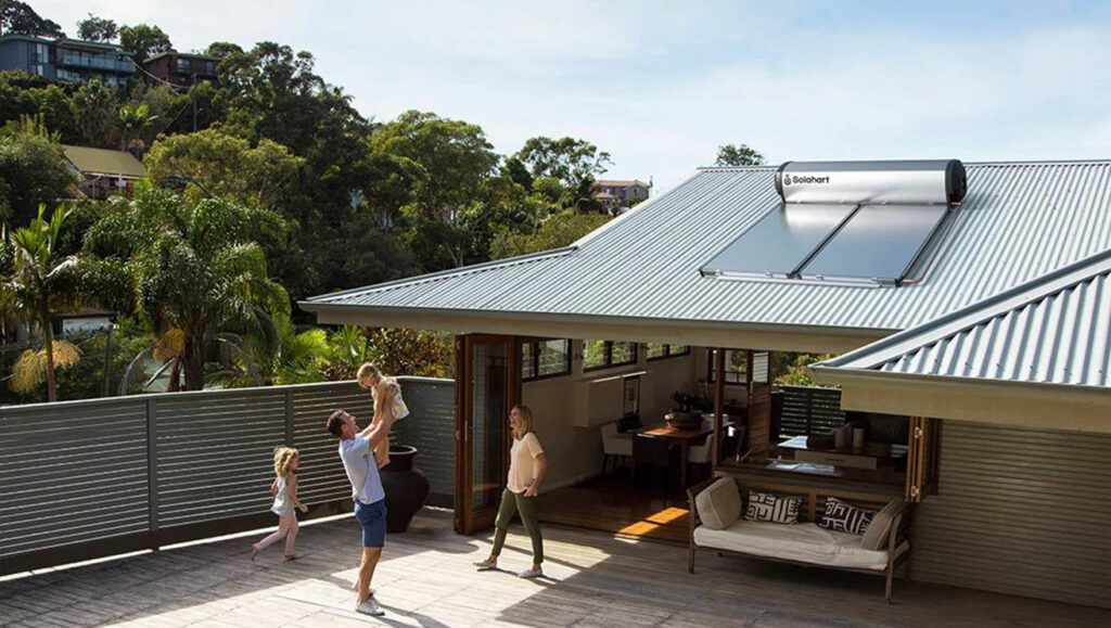 family playing in backyard with solar panels seen on the roof